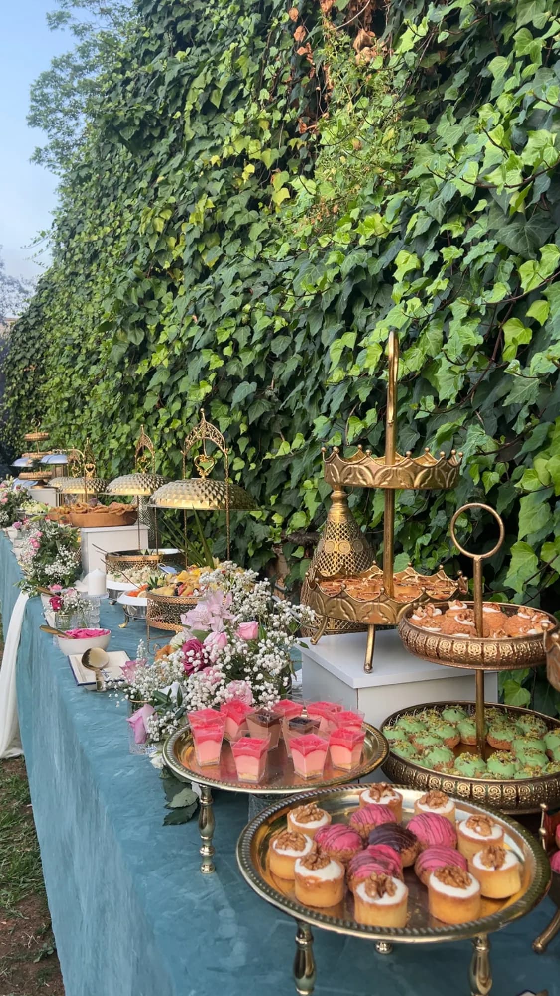Buffet de douceurs devant un mur de lierre