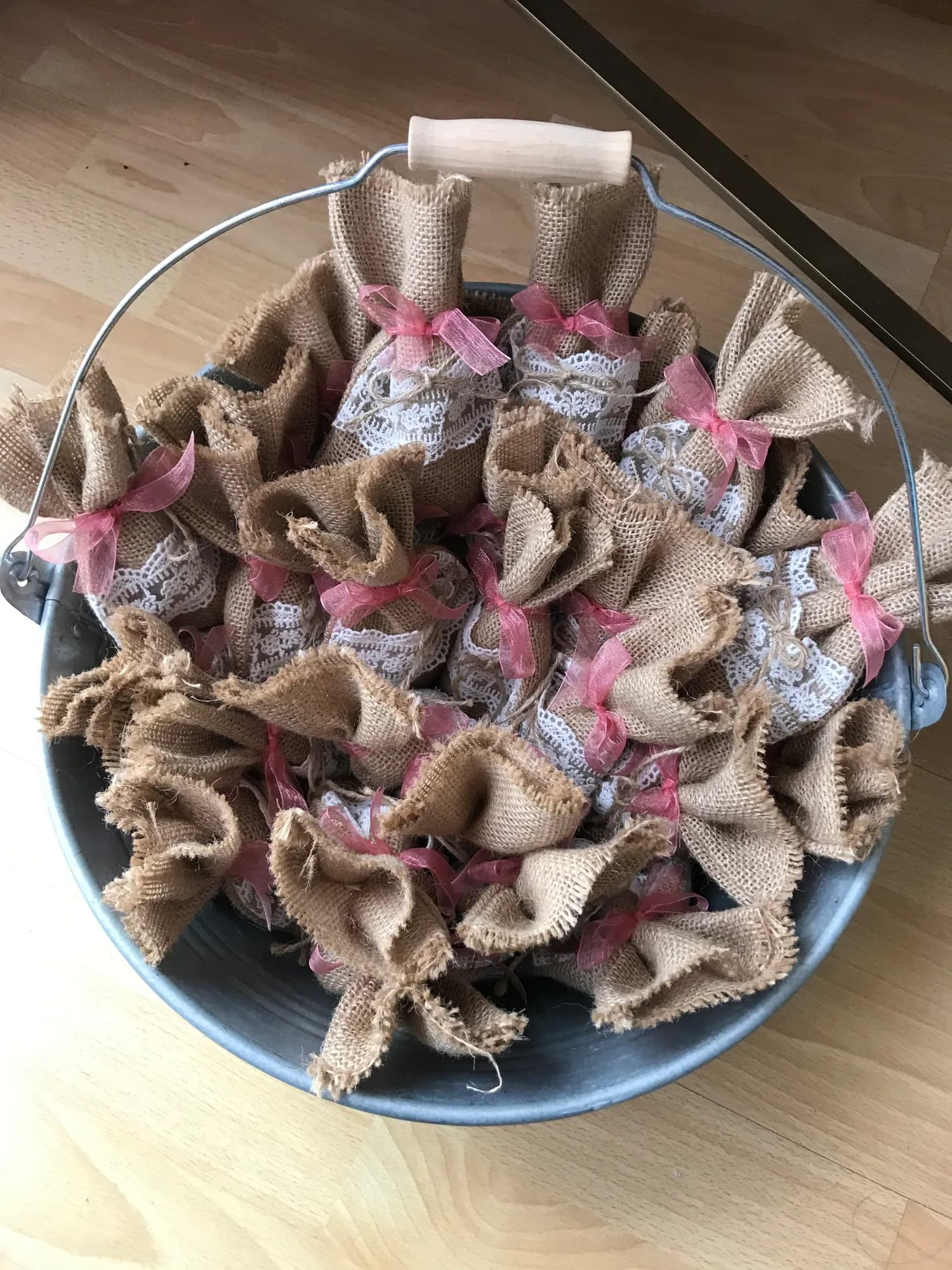 Sachets de jute noués de rose, réunis dans un seau