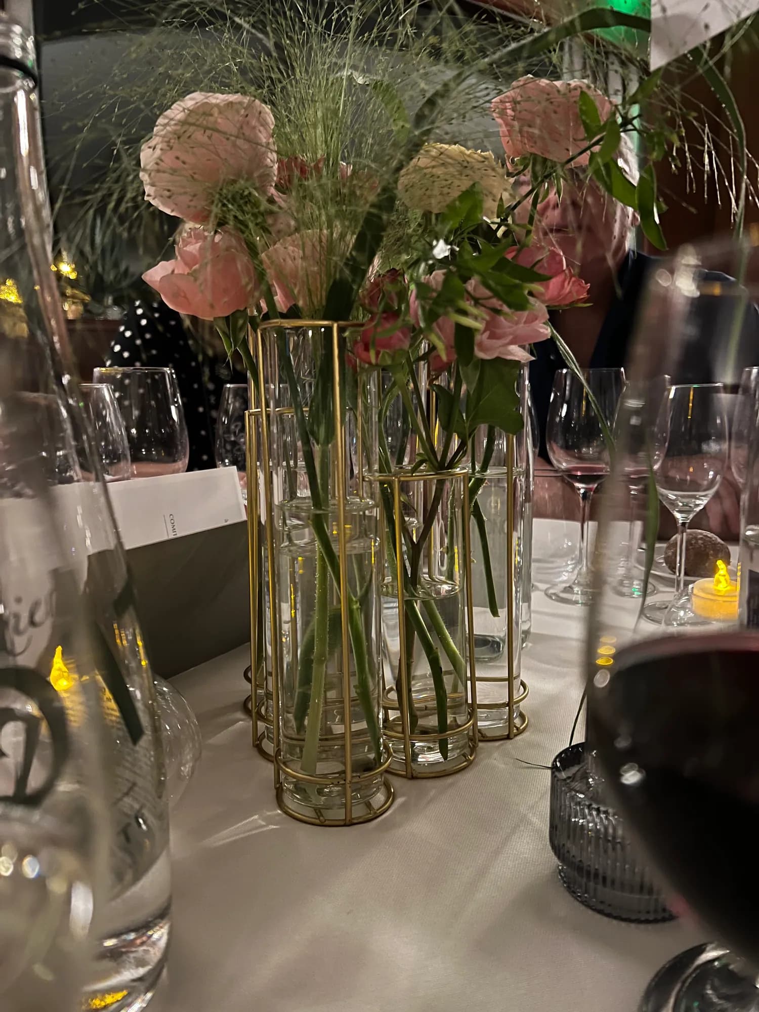 Table fleurie, vases en verre et supports dorés